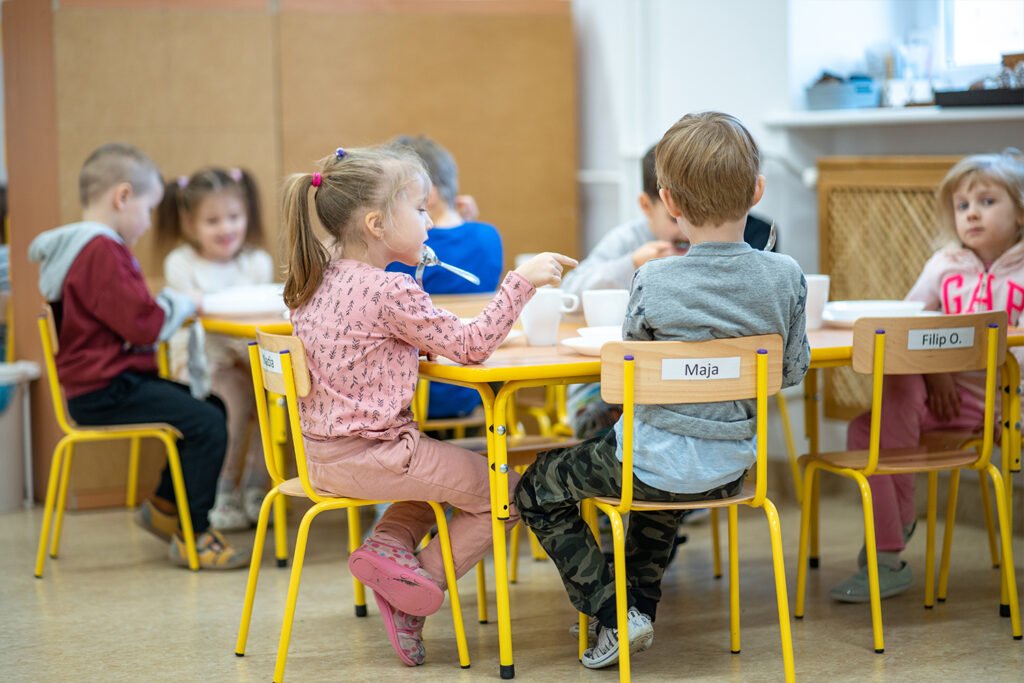 dzieci w przedszkolu spożywają posiłek
